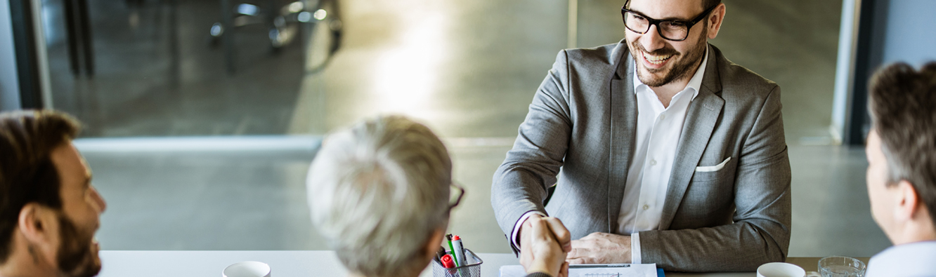 A man shaking hands with an interview panel.