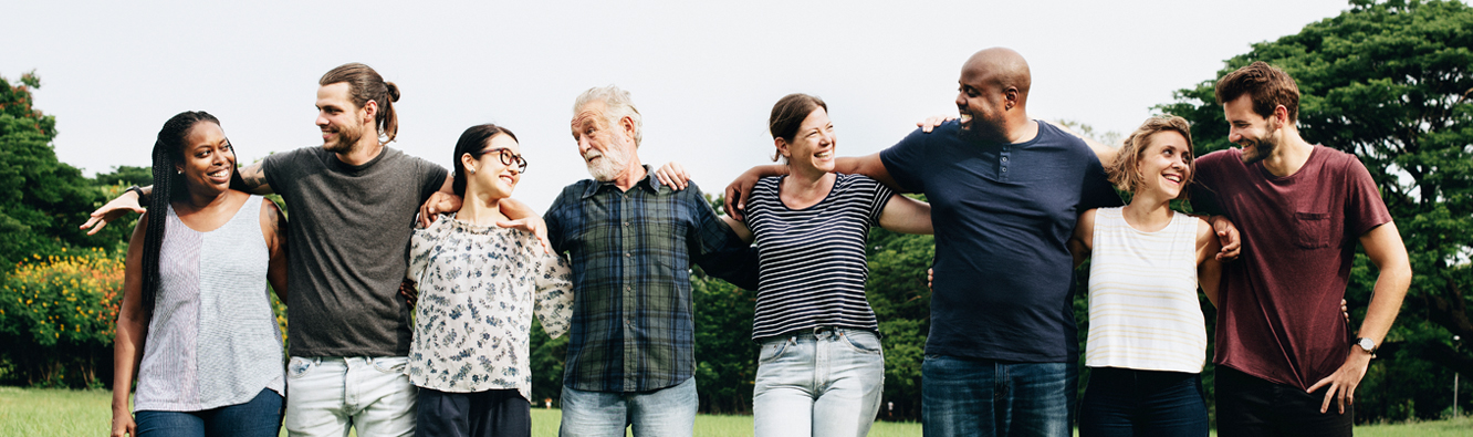 A diverse group of individuals hugging each other.