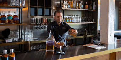 Albany Distilling Co-owner John Curtin pouring a cocktail at Albany Distilling Bar & Bottle Shop