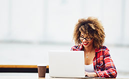 Woman smiling at her laptop.