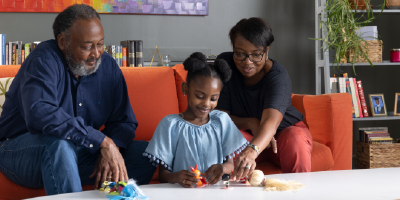 Family in office and child playing with toys