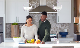 Couple preparing food in modern kitchen.