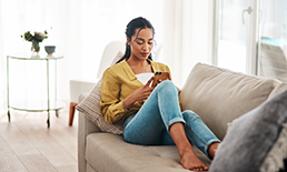 woman on a couch looking at a mobile device