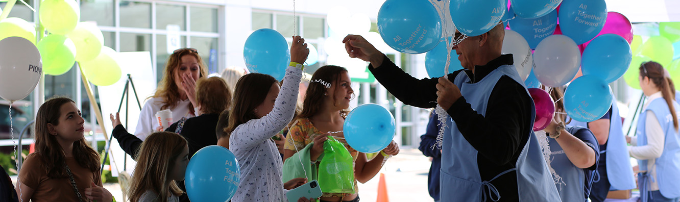 Thomas Signor - EVP & Chief Administrative Officer handing out balloons at Pioneer Grand Carnival