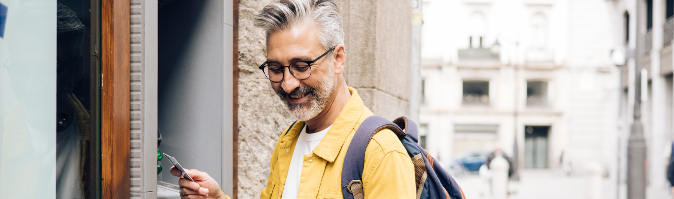 Man using an ATM with card while traveling