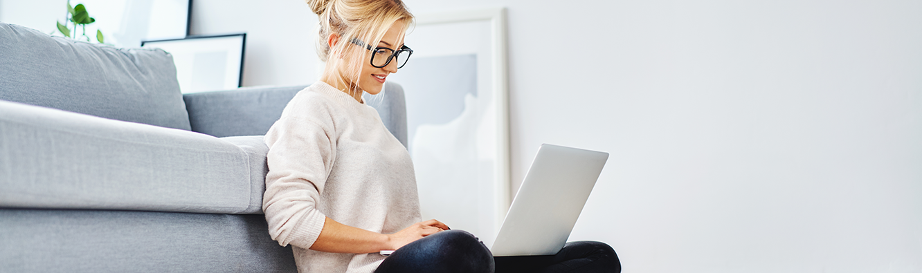 woman sitting on the floor looking at a laptop