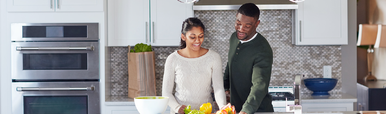 Couple preparing food in modern kitchen.