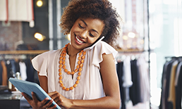 woman talking on the phone and using her tablet at the same time.