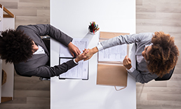 Ariel view of people at a desk shaking hands