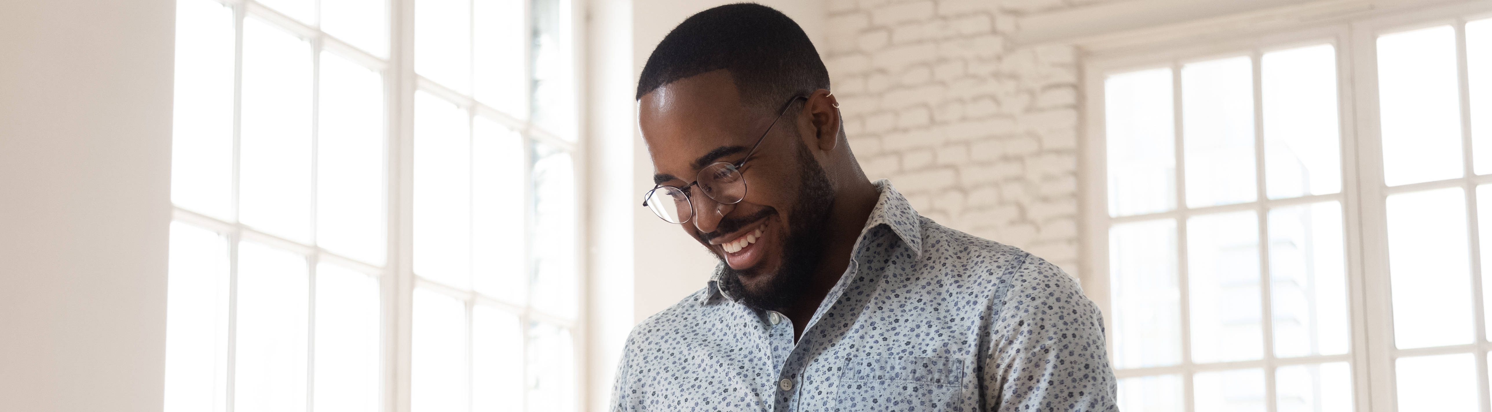 man smiling and looking at mobile device