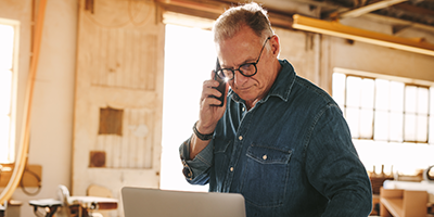 man on the phone looking at a computer