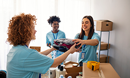 Young adults volunteer to sort clothing and products.