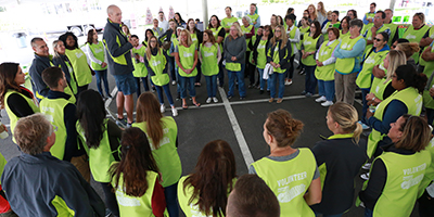 team members listening to man on microphone