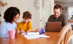 family sitting at a table working