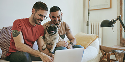 two man and dog looking at computer