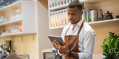 man working in a store looking at a tablet