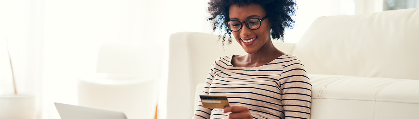 woman with her laptop open looking at credit card