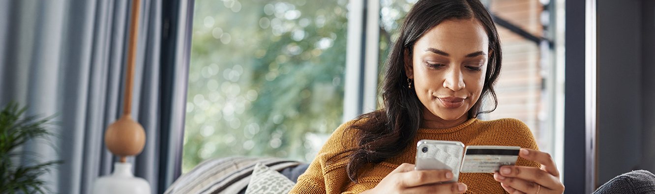 Woman typing her credit card information into her cellphone