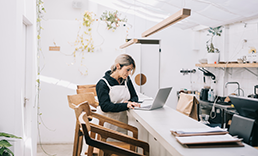 Woman in apron looking at  computer.