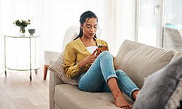 Woman on couch looking at her phone