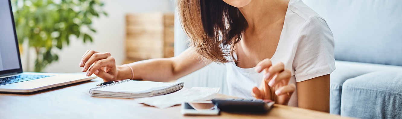 woman using calculator and laptop