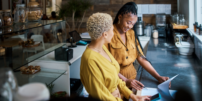 Small business owner having a discussion with employee in bakery