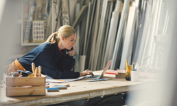 Woman checking computer at woodworking shop