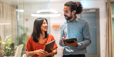 Man and woman walking through workplace having a conversation