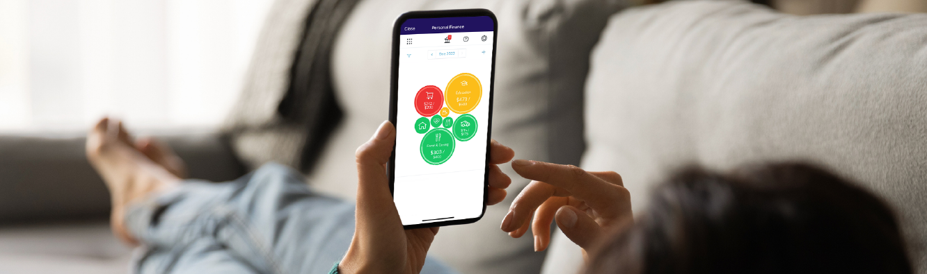 Woman on the couch checking the Personal Finance Tool in the Pioneer app.