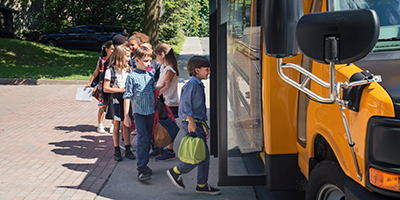 children in line to get on a school bus