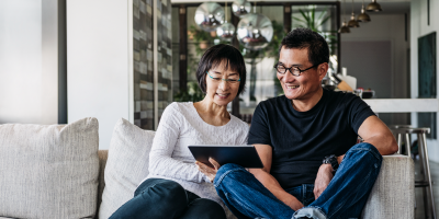 Couple on couch looking at tablet