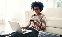 woman with her laptop open looking at credit card