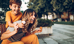 Mom with son behind her, both laughing