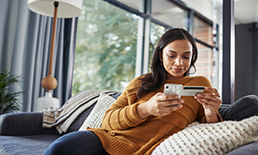 Woman typing credit card information into phone