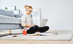 woman sitting on the floor looking at a laptop