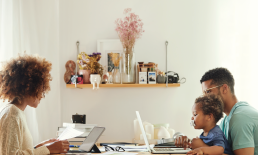 Husband and wife sitting with child working on computers. 