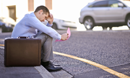 man sitting on a curb with briefcase