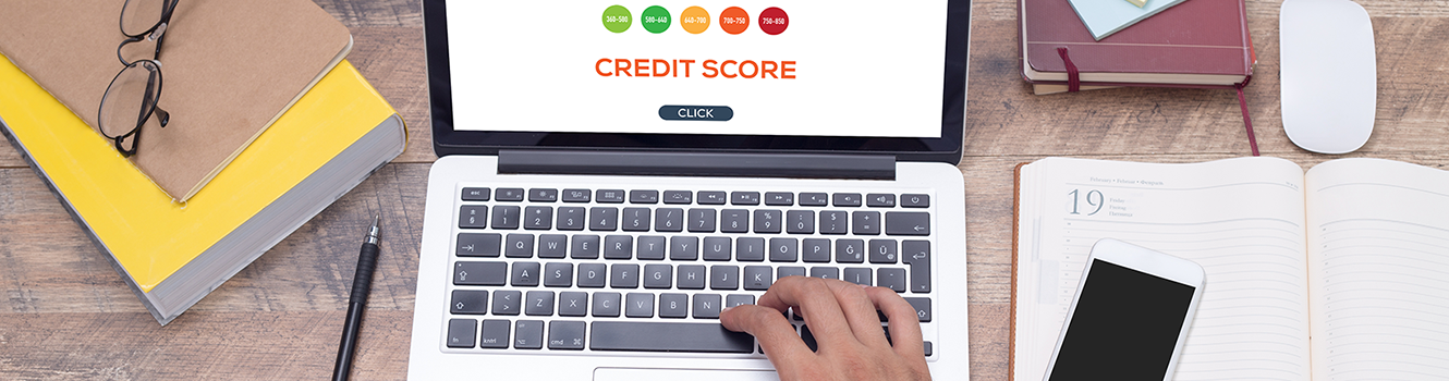 Checking computer with credit score report on desk