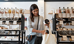 Woman putting jars in tote bag