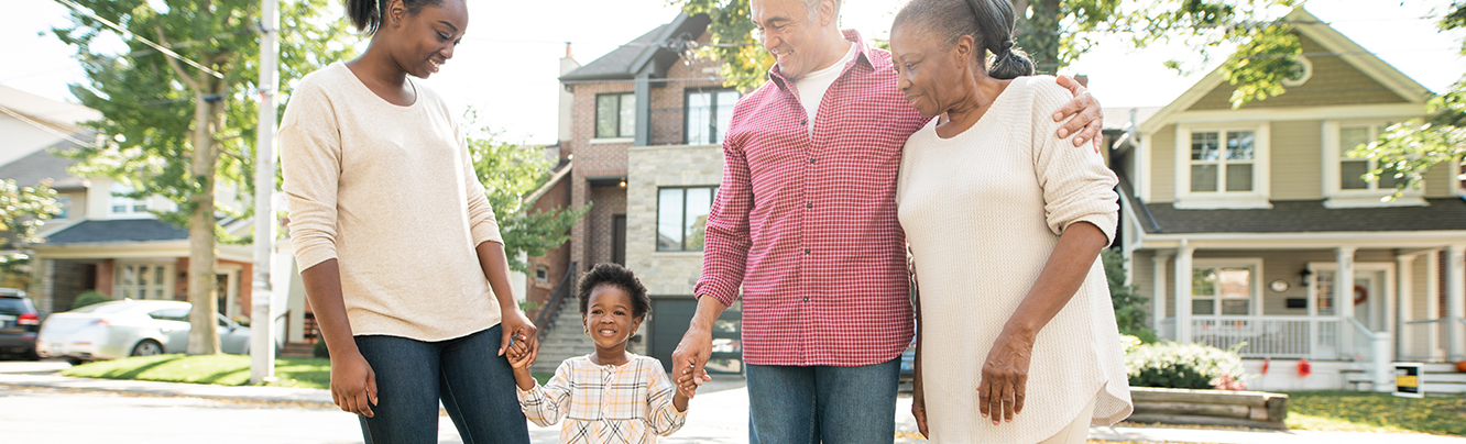 family standing outside in front of homes