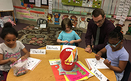 Man sitting with small children at a table
