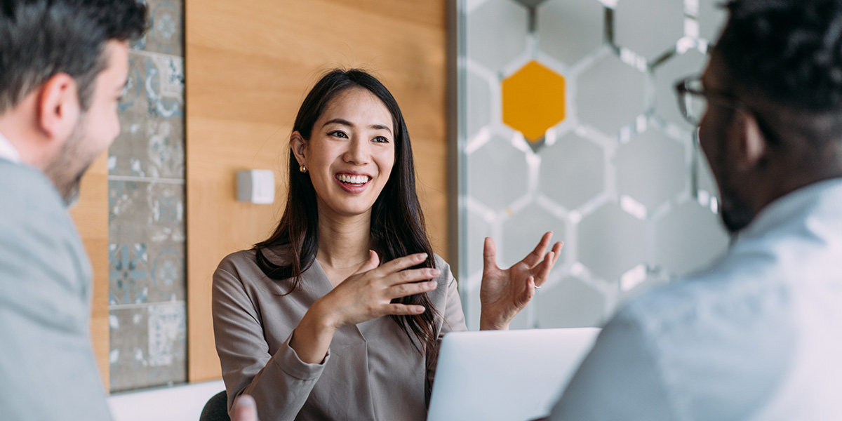 woman chatting with two men in office conference room